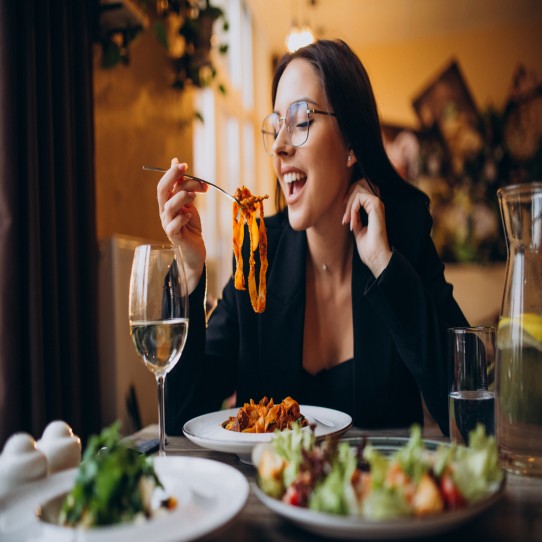 young woman eating pasta cafe 1